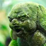 A stone statue covered in moss.