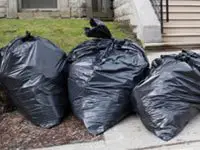 Garbage bags on the front curb.