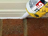 Caulking between trim and brick on the outside of a house.